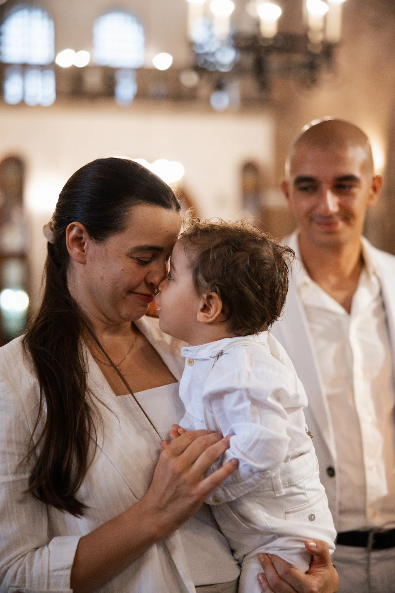 Майка целува бебе – кръщене