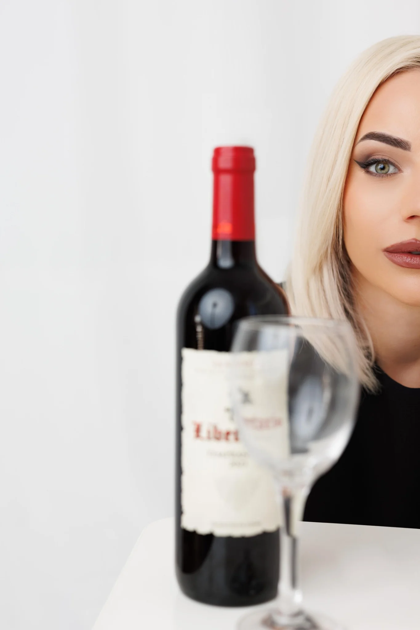 Студиен портрет с бутилка вино и винена чаша