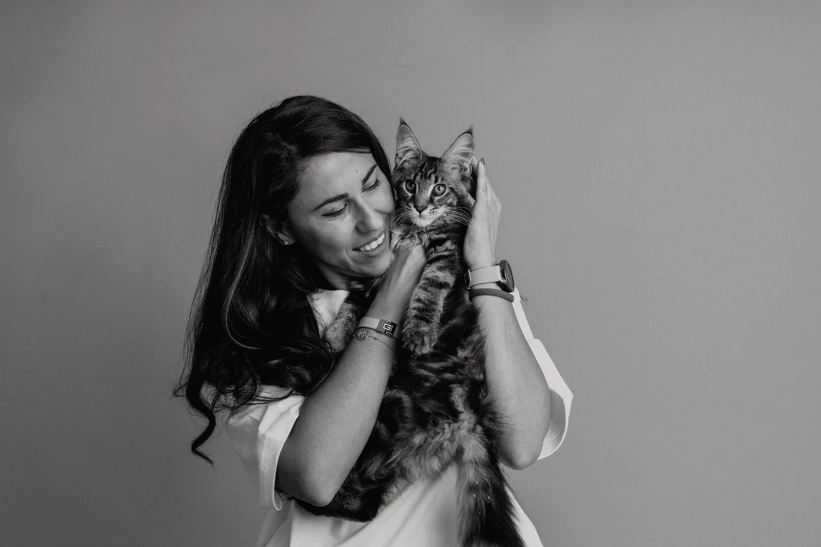 Черно-бял студиен портрет на жена с котенце